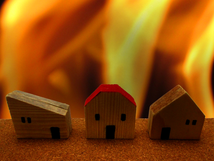 炎にさらされる家の模型
